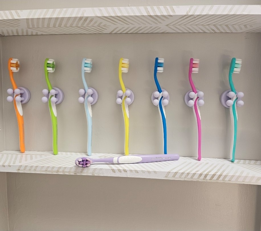 Wall-mounted silicone toothbrush holders with a row of toothbrushes