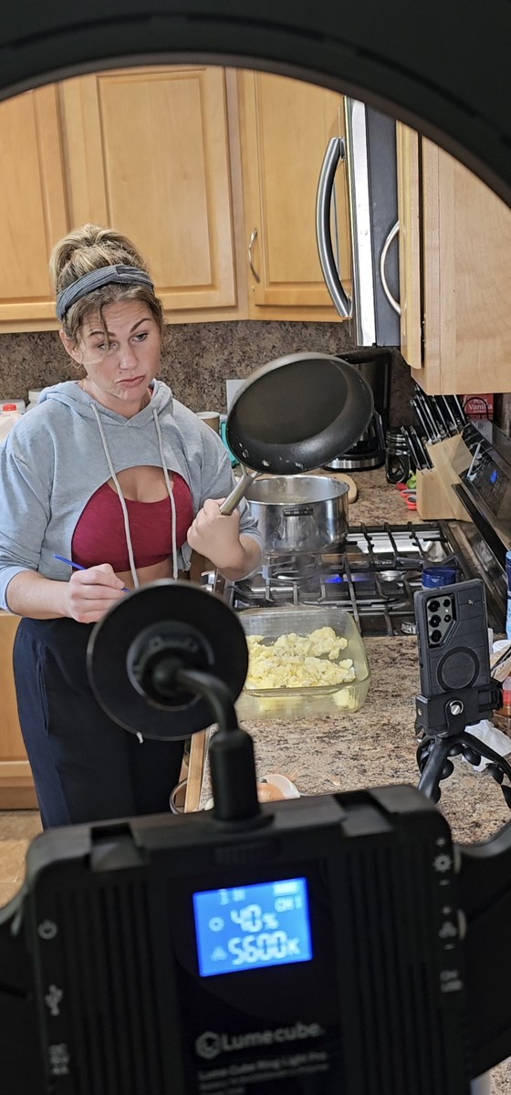 Bridget filming content in her kitchen with lighting gear